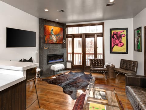 Lift Lodge 102 has a living room with leather furnishings and colorful art.