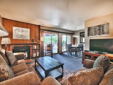 Living room features a comfortable fabric couch and love seat with a large flat-screen TV
