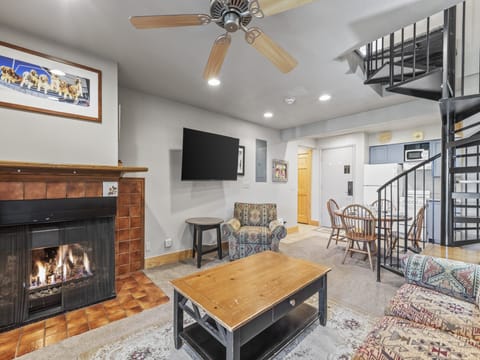 Snow Flower 72's living room with fireplace, flat screen TV, and open concept open to the dining and kitchen area.