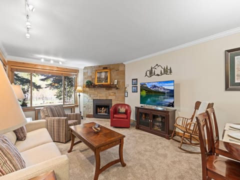 The living room with comfortable furnishings, cozy fireplace and flat screen TV.