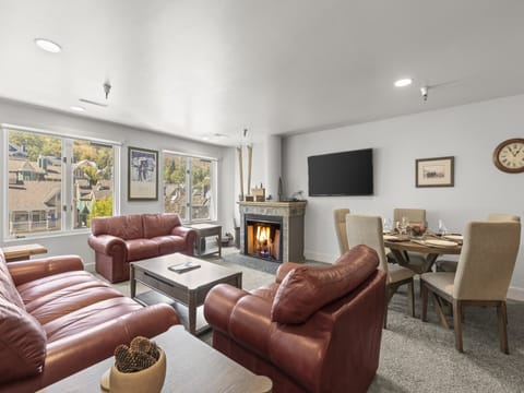 The living room with comfy red leather furniture and cozy fireplace.