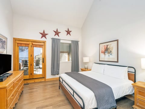 The king primary suite is situated on the upper level of the condo and has a spacious sunny private deck