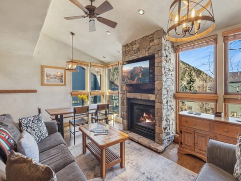 Floor-to-ceiling windows fill the space with natural light, making the living and dining area feel open and airy.