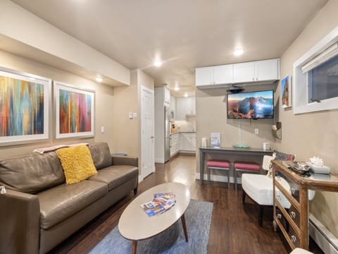 Flat screen TV in the living area, with sleeper sofa, full kitchen and comfortable eating area.