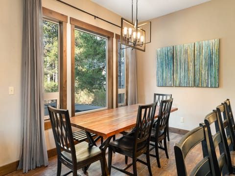 ather around the spacious wood dining table with seating for eight plus bar stools - Rustic beam accents and candlelight ambiance create a mountain lodge charm - Open layout connects seamlessly to kitchen and living space