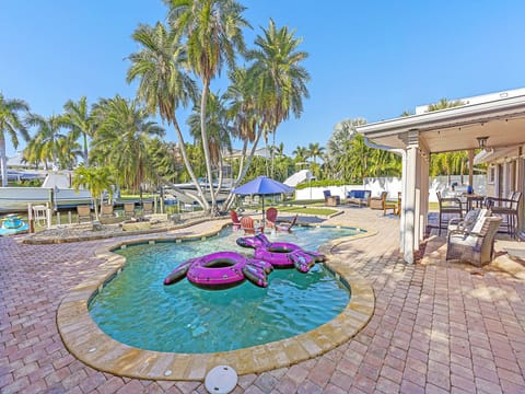 Backyard oasis, heated pool, putting green, pool loungers, and outdoor seating.