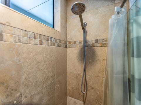 Rinse away the day under a soothing rainfall showerhead, with natural light spilling in and elegant tilework surrounding you in spa-like comfort.