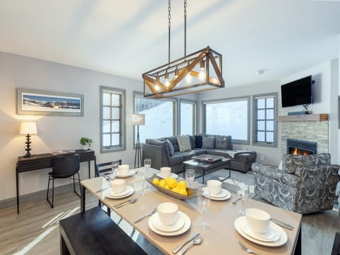 The living room of Etta Place 111 features an open plan kitchen, dining and lounge area with views of the ski run.