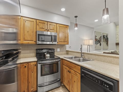 The kitchen has wood cabinets and stainless steel appliances.