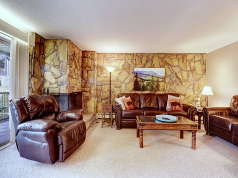 Living room features a wood burning fireplace and access to the private patio.