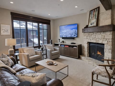 Sink into plush seating by your crackling fireplace, where stone textures and warm lighting create the perfect mountain retreat atmosphere.
