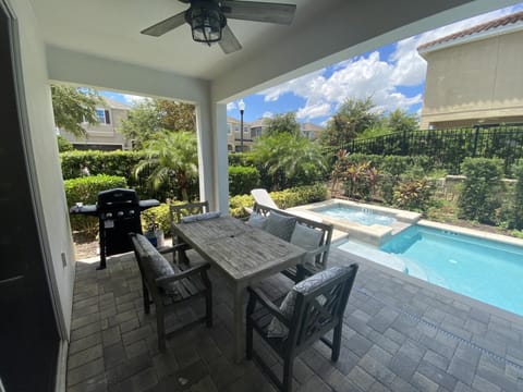 Covered patio with outdoor dining and a stunning poolside view.