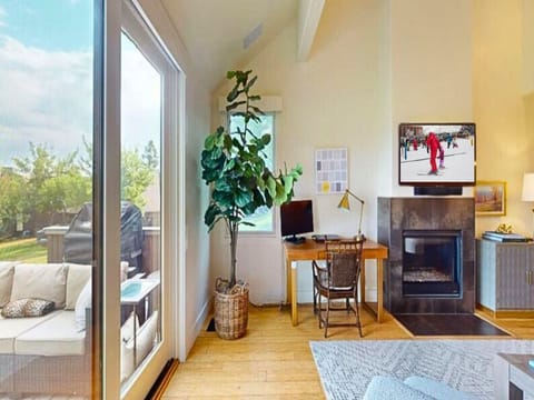 Cozy living room offers plush seating, 50” smart TV, gas fireplace, work desk, access to a private deck