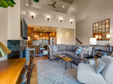 Cozy living room offers plush seating, 50” smart TV, gas fireplace, work desk, access to a private deck