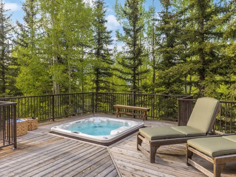 The expansive deck features an 8 person hot tub with lounging chairs, outdoor dining and mountain views.