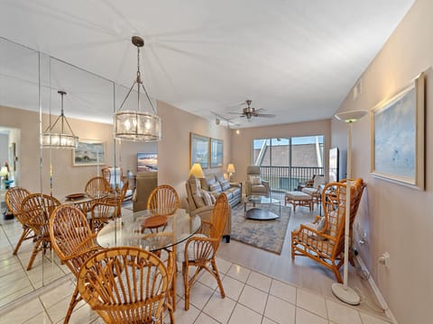 Spacious and open dining area with kitchen breakfast bar with additional seating, and an open living room with access to private screened in balcony.