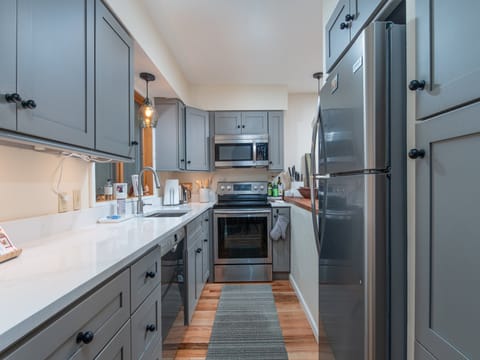 Updated galley kitchen with modern appliances, opening to the living and dining areas for easy entertaining.