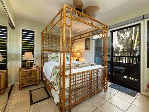 Drift off in this tropical-inspired bedroom with its unique bamboo canopy bed, tile floors, and private balcony access just beyond your door.