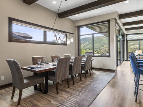 The dining area with seating for 8 guests on high back upholstered chairs and views of the Park City Mountains Resort.