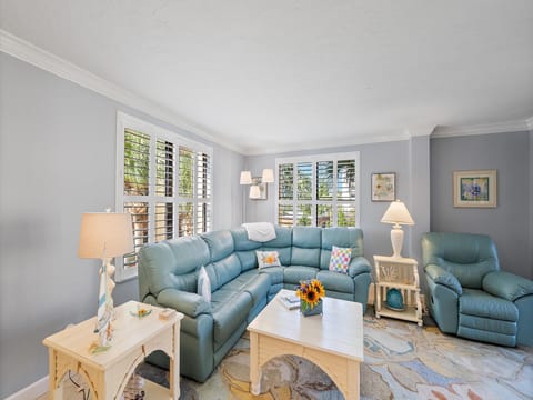 Settle into this spacious living room where comfort meets coastal charm - sink into the plush sectional sofa and enjoy the natural light streaming through plantation shutters.