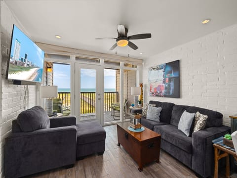 Relax in the bright, cozy living room with easy access to the balcony and ocean breeze