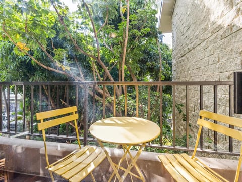Your private balcony awaits with sunny seating nestled among lush greenery, where morning coffee feels like a tranquil garden escape right from your room.