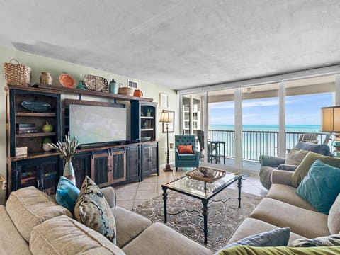 Sink into plush sofas while ocean waves dance beyond your floor-to-ceiling windows in this elegant beachfront living room.