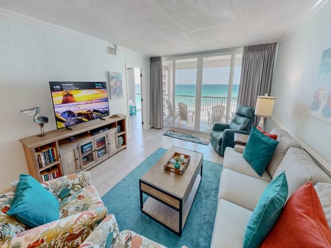 Unwind in your oceanfront living room where turquoise accents mirror the sea views through floor-to-ceiling windows onto your private balcony.