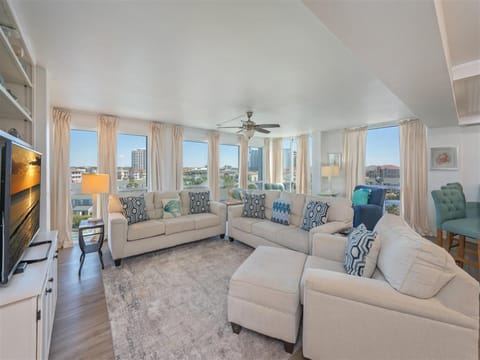 Unwind in your spacious living room with panoramic city views through floor-to-ceiling windows and comfortable seating for the whole group.