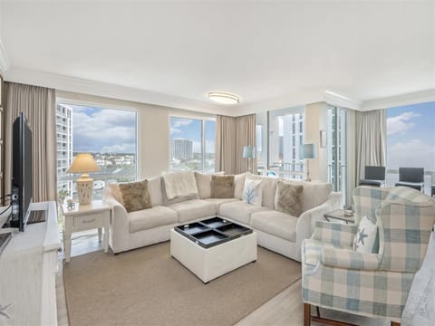 Relax in your bright living room with plush seating and stunning city views through floor-to-ceiling windows.