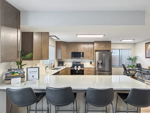 Your fully equipped kitchen features stainless steel appliances, and a spacious breakfast bar perfect for casual dining.