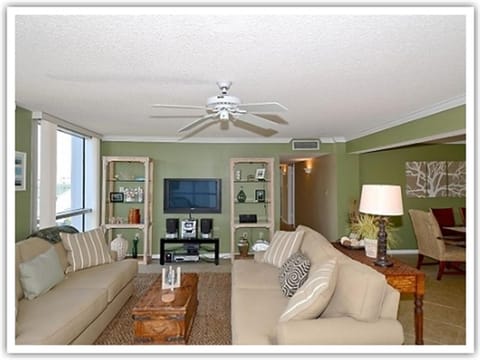 Relax in your stylish living room with comfortable seating, entertainment center, and soothing green walls that create the perfect retreat.