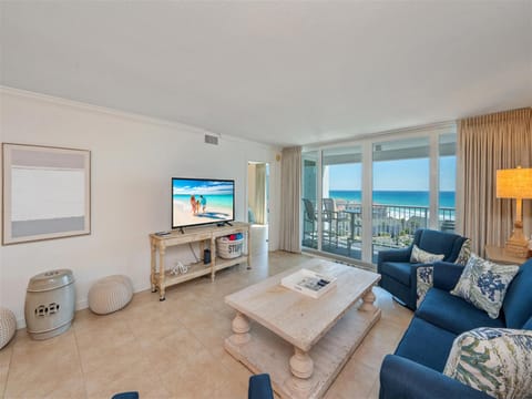 Sink into plush blue sofas while enjoying stunning ocean views through floor-to-ceiling windows in your coastal retreat.