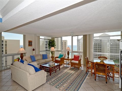 Your spacious living room features floor-to-ceiling windows showcasing stunning city views, comfortable seating, and warm lighting for perfect relaxation.