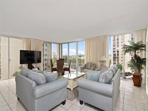 Unwind in your bright living space with plush seating and panoramic city views through floor-to-ceiling windows.