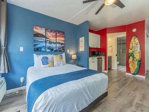 Sink into your comfortable bed surrounded by vibrant beach-themed decor and a convenient kitchenette for your perfect getaway.