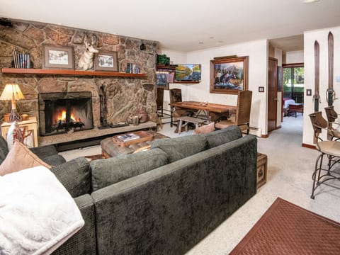 Curl up by your roaring stone fireplace in this inviting living room, where rustic charm meets mountain elegance and every detail invites you to unwind in comfort.