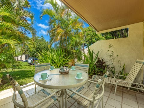 Sip your morning coffee in this covered lanai nestled among lush tropical palms and vibrant greenery—your private escape for peaceful outdoor moments.