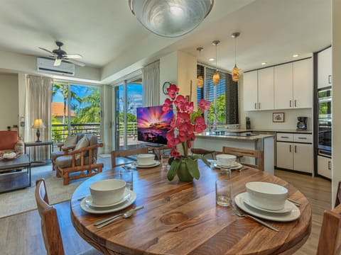 Gather around this handcrafted wood table where vibrant orchids welcome you to bright island mornings, with your chef-ready kitchen, airy living space, and lush tropical views just steps away.