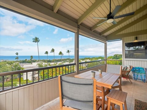 Picture yourself sipping your morning coffee at this covered lanai, where gentle trade winds meet sweeping ocean and palm-framed views. The outdoor dining setup invites you to linger over meals while soaking in Hawaii's endless blue horizon.