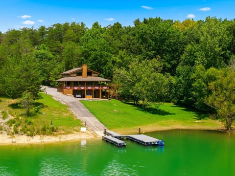 This charming lakefront property sits nestled among lush trees with direct water access and a private dock, offering a serene natural setting for summer escapes.