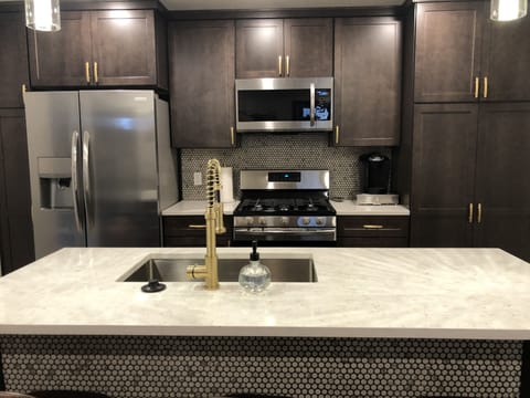 Kitchen with stainless steel appliances and quartz countertops.