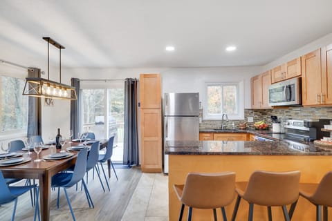 Open floor dining area with 8 chairs and 4 additional counter stools.