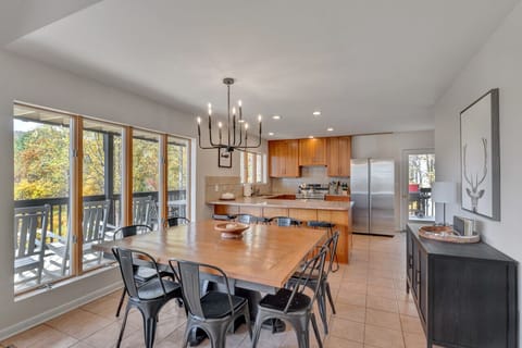 A dining table that seats 10 people is inside plus 4 barstools
