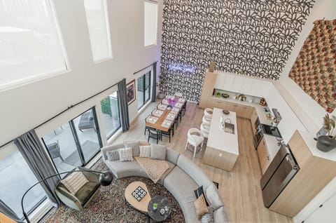 Main Level: Bright open floor living area featuring a large smart flat-screen TV, designer furnishings, and entrance to a large private patio.