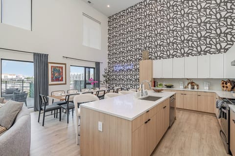 Main Level: Fully equipped kitchen with stainless-steel appliances and essential supplies, complemented by a bar seating for 4, seamlessly connecting to the spacious dining area for a perfect blend of functionality and style.