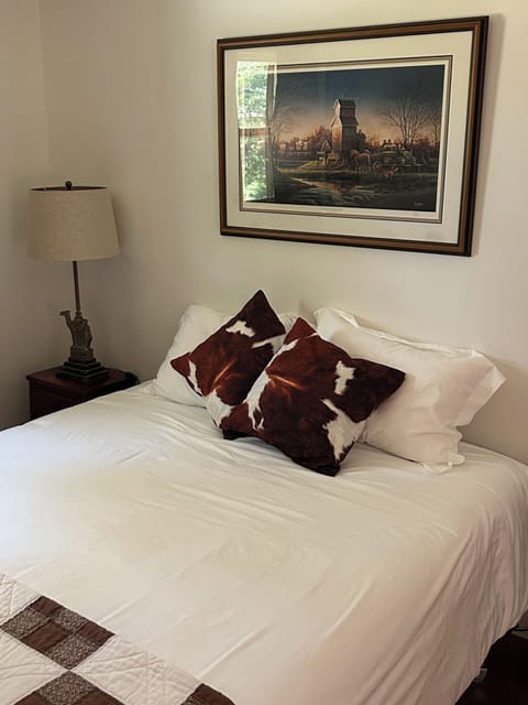 The Man Cave bedroom has a queen bed with floor length dark drapes for sleep in.