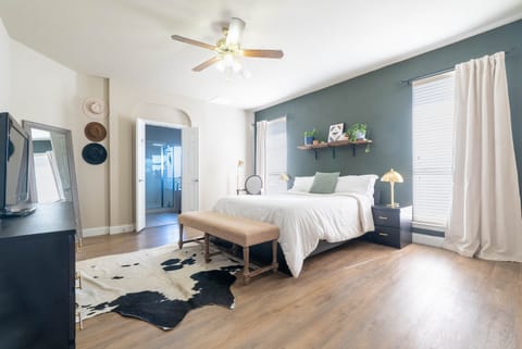 Large master bedroom with desk, smart tv and king size bed