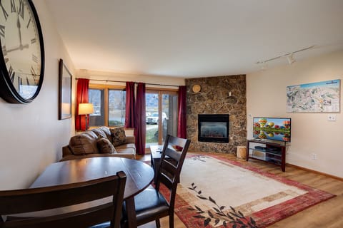 Cozy up by your stone fireplace after mountain adventures. This warm living space blends comfort with style for perfect evenings.