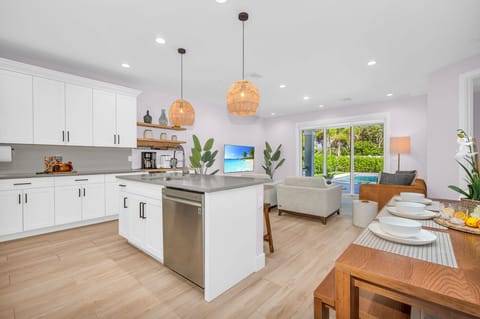 The open plan layout connects the kitchen seamlessly to the dining and living areas, allowing for easy flow and interaction with guests. It's perfect for hosting dinner parties and family gatherings.